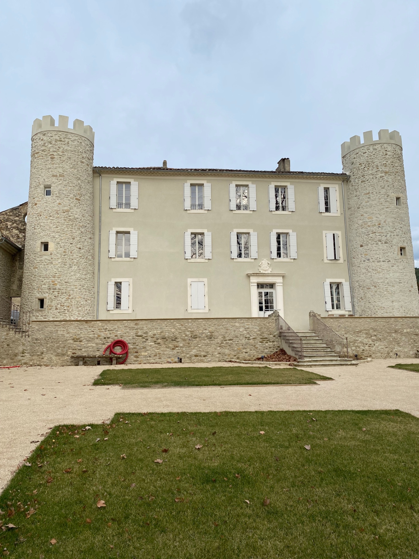 Façade restaurée d'un château avec deux tours en pierre dans le Vaucluse
