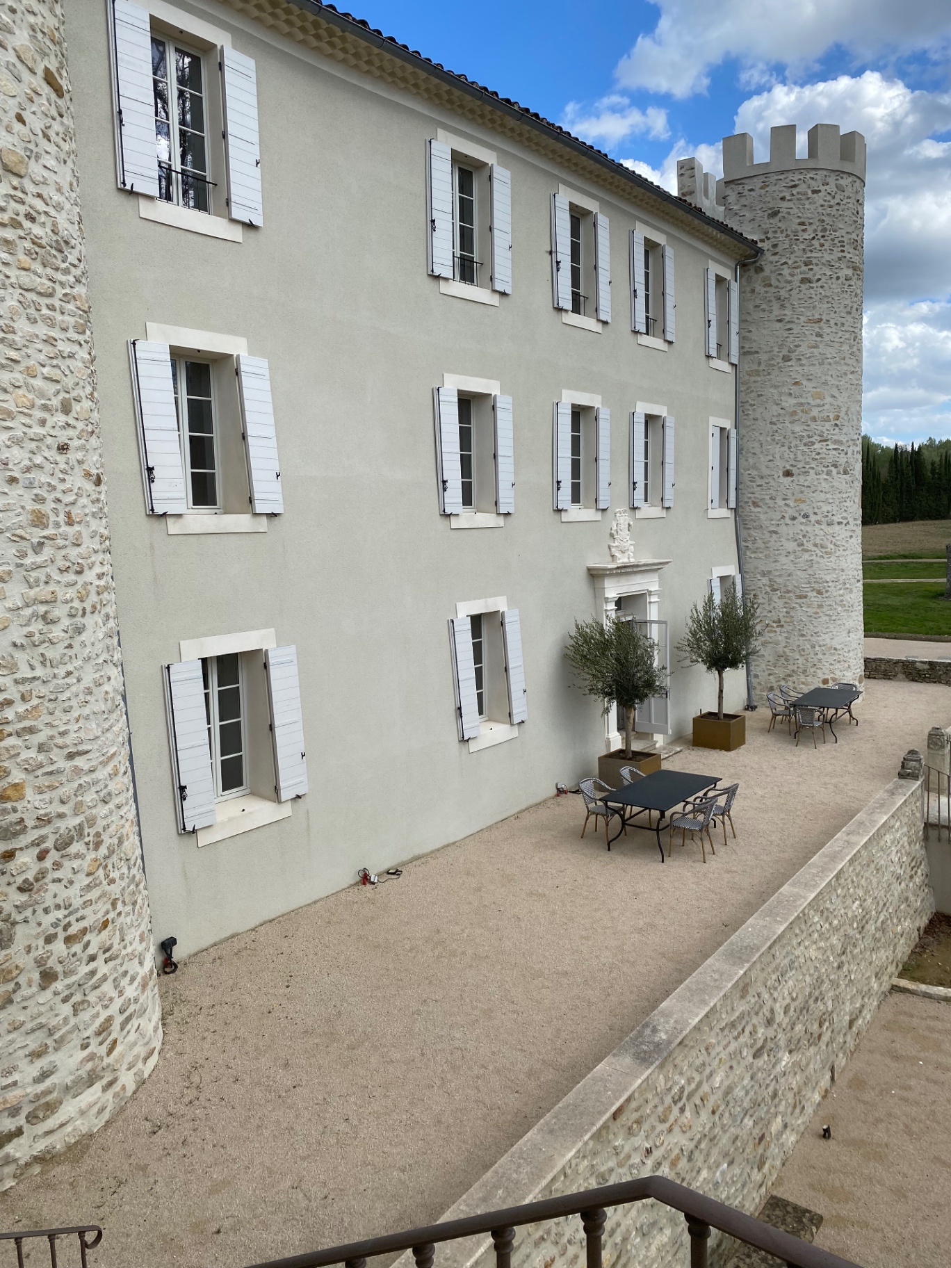 Façade latérale du château restauré avec terrasse et tour en pierre